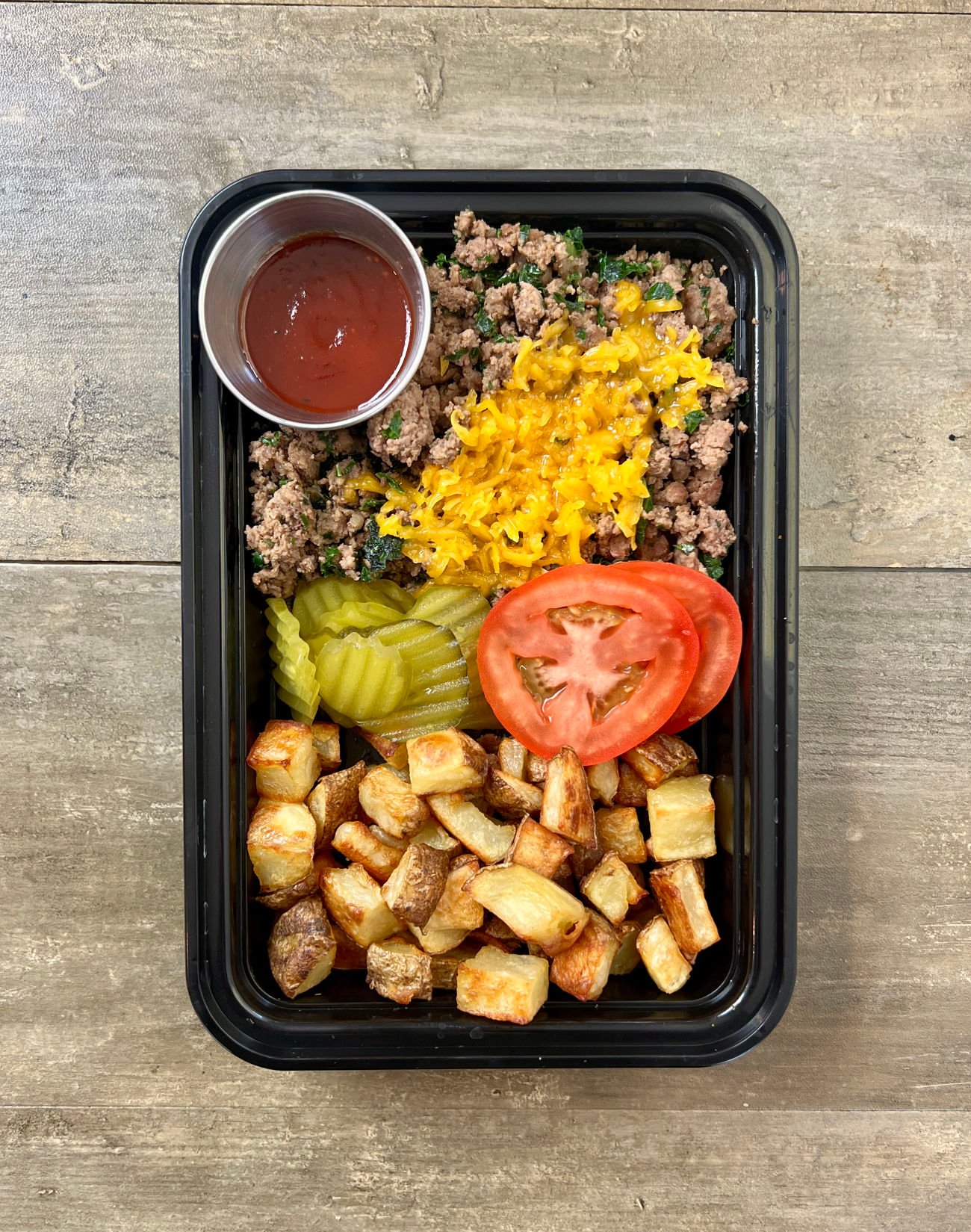 BBQ Cheddar Burger Bowls in black meal prep bowl.