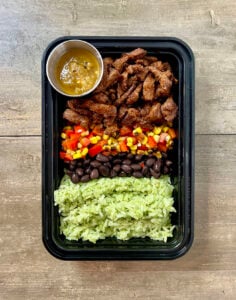 Honey Lime Steak Burrito Bowls in black meal prep container.