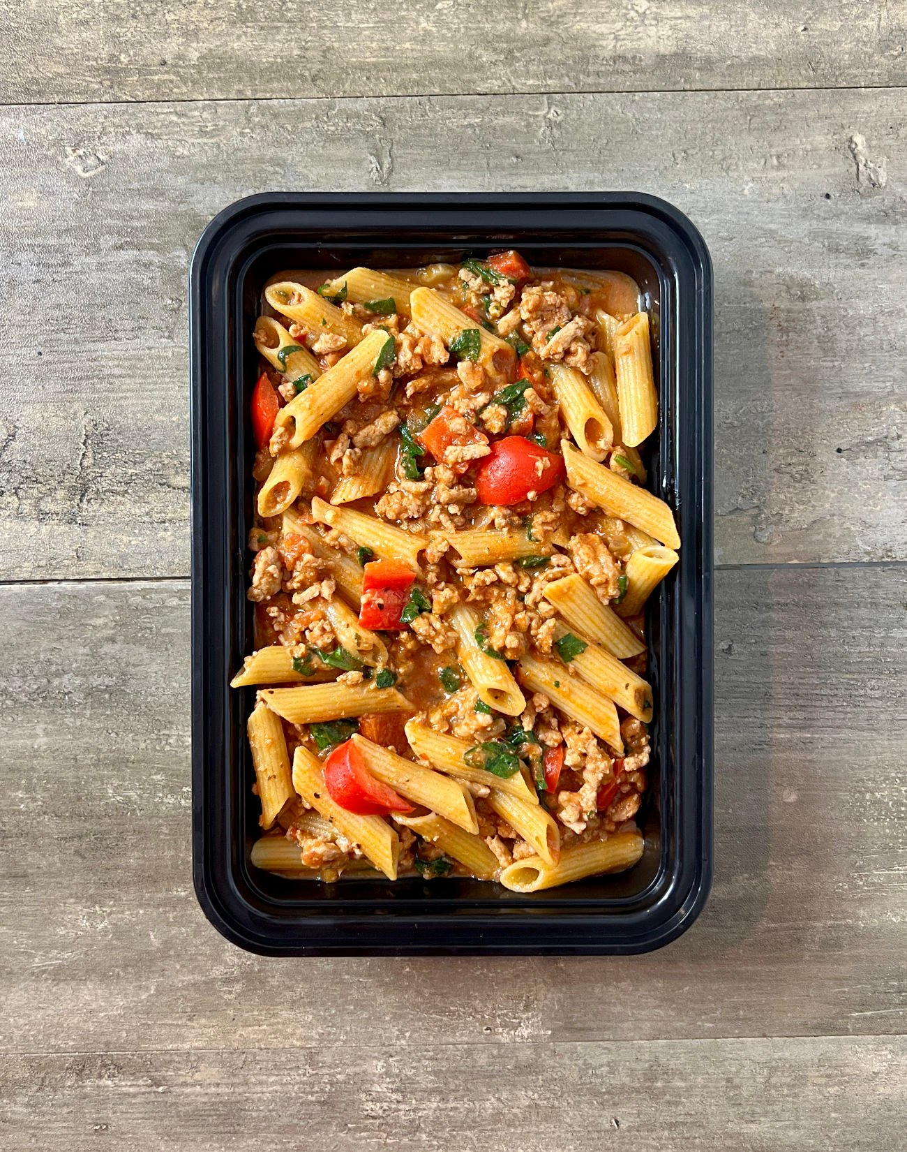 One Pot Sausage and Pepper Pasta in black meal prep container.