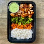 Creamy Cilantro Chicken Bowls in black meal prep container