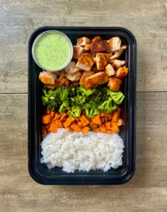 Creamy Cilantro Chicken Bowls in black meal prep container